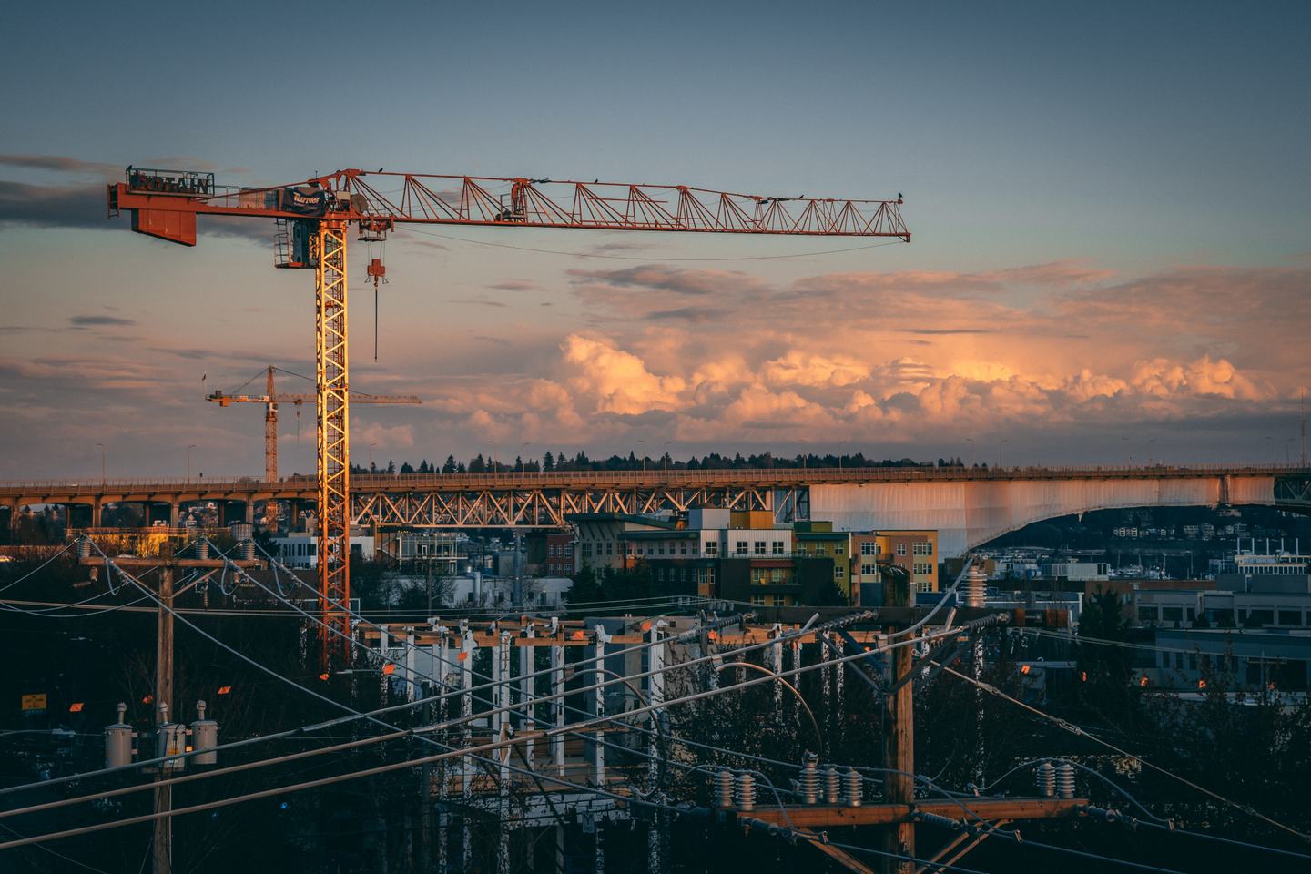 Tower cranes over a construction site at dusk